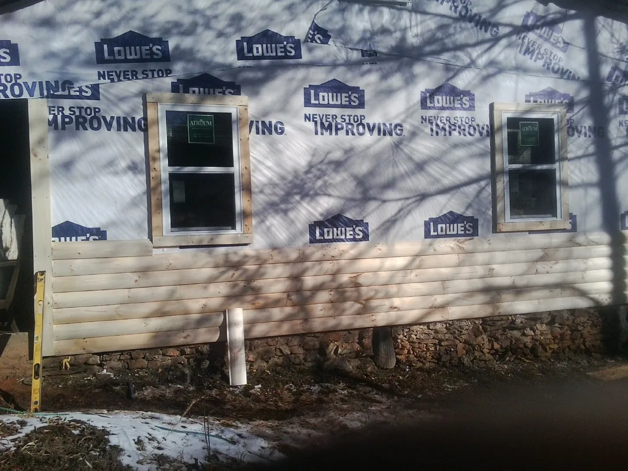 House wrap and new log siding going up on an exterior wall in Orrtanna