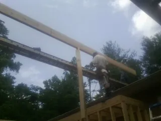 Carpenter setting a ridge beam over a new addition frame — Ice Dam Removal by Roofing Brothers in Orrtanna