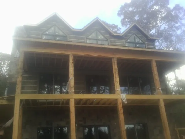 Dormers and porch framing on a large log home under construction — Roof Coating work by our crew in Orrtanna